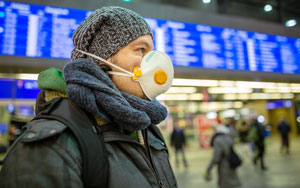 man at a train station with a mask