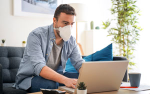 masked man using laptop