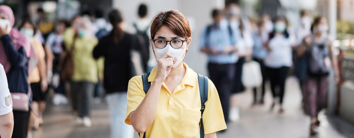 woman wearing mask walking thru a crowd