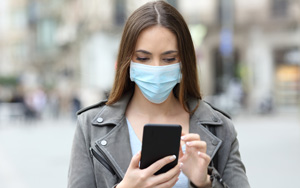 masked woman using smartphone