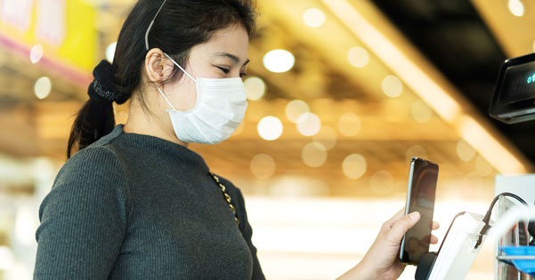 masked woman buying using smartphone