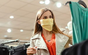 masked woman shopping for clothes