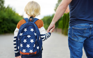 Man leading son to school
