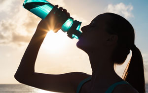 athletic woman drinking sports drink on a sunny day