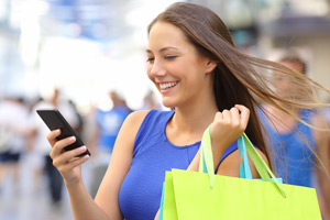 woman shopping holding a bag and phone