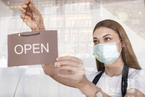 masked woman opening a store